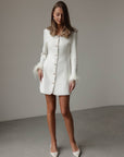 Abito in tweed bianco con polsini in piume