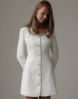Abito in tweed bianco con polsini in piume
