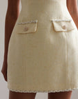 Vestido de tweed amarillo pastel con detalles dorados