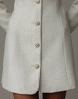 Abito in tweed bianco con polsini in piume
