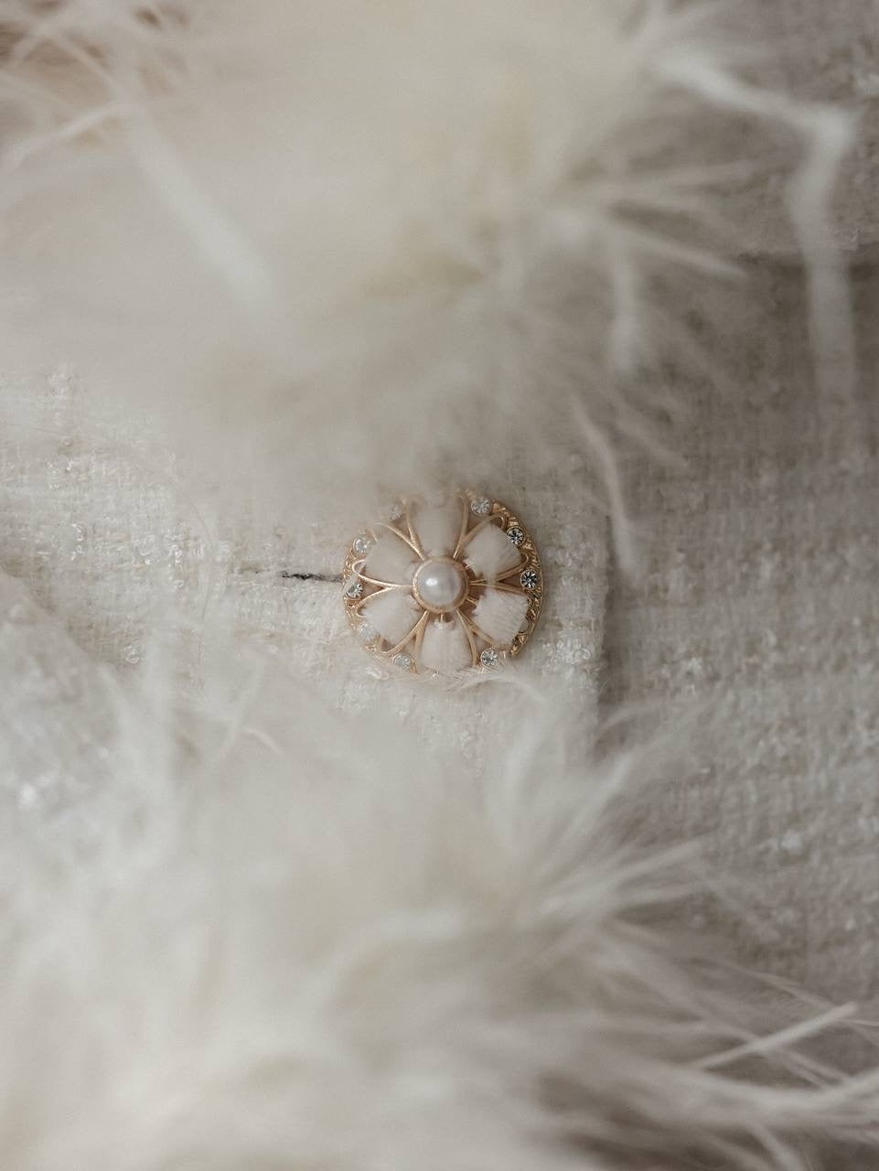 Abito in tweed bianco con polsini in piume
