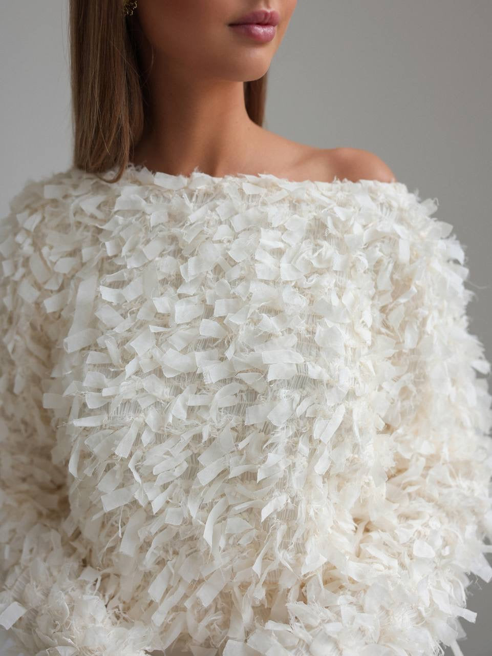 Blusa texturizada con detalles de plumas