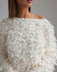 Blusa texturizada con detalles de plumas