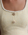 Vestido de tweed amarillo pastel con detalles dorados