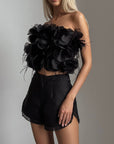 Top negro con flores y plumas