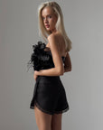 Top negro con flores y plumas
